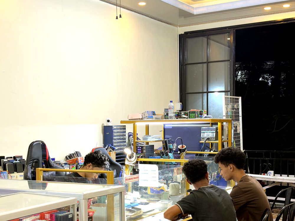 Teknisi sedang mengerjakan servis HP